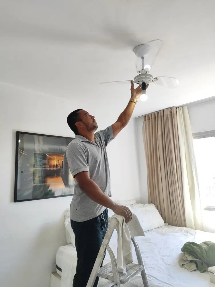 Eletricista instalando ventilador de teto